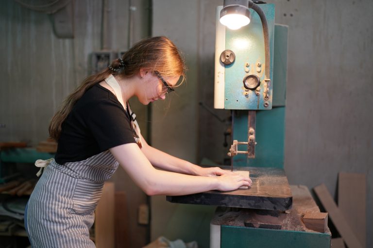 Small business of a young woman in furniture workshop background.